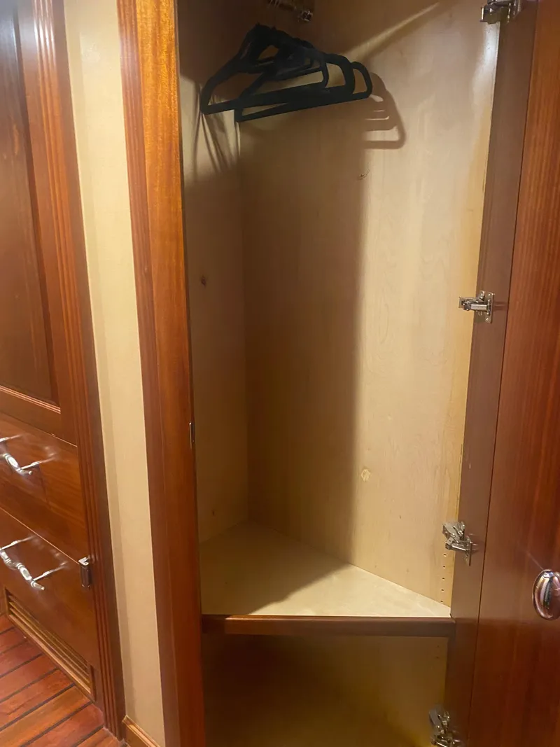 Slide: The Image of Wooden closet interior with hangers, part of a 2018 Allseas Expedition model. - 38