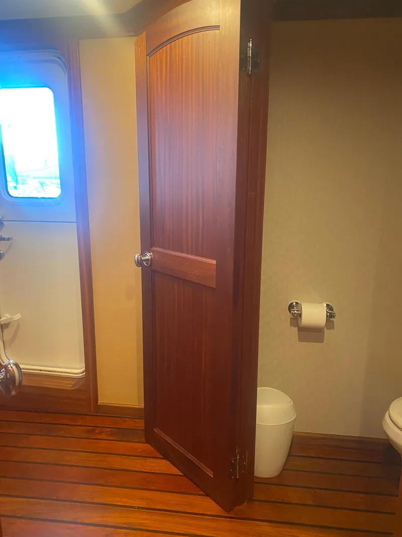 Slide: The Image of Wooden bathroom interior on 2018 Allseas Expedition yacht, featuring door, window, and toilet. - 39