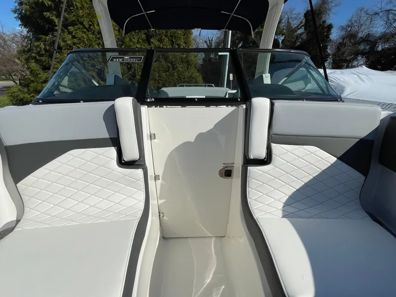 Slide: The Image of 2025 Chaparral 267 SSX boat interior with white quilted seating and sleek design. - 18