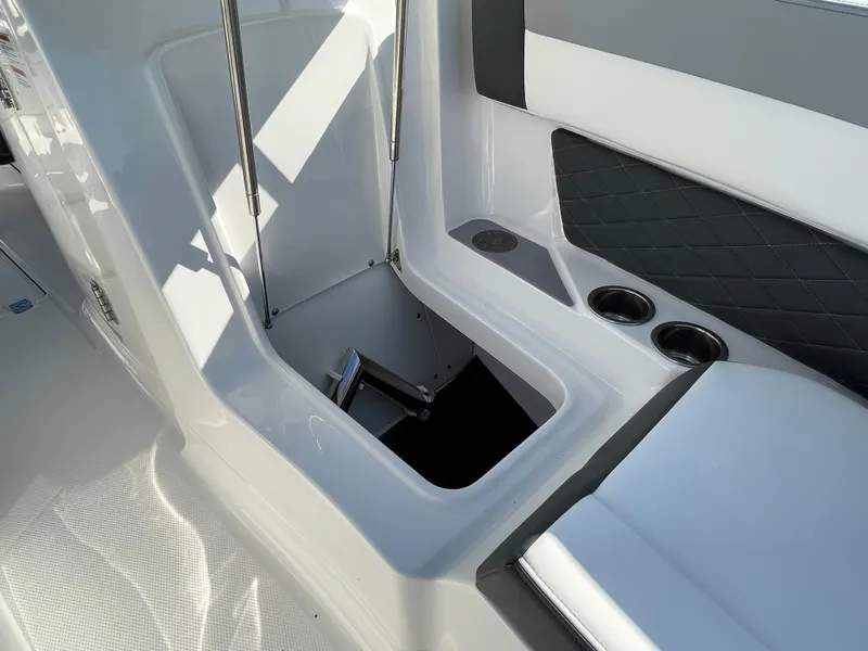 Slide: The Image of 2025 Chaparral 267 SSX boat interior storage compartment with cup holders and seating. - 13
