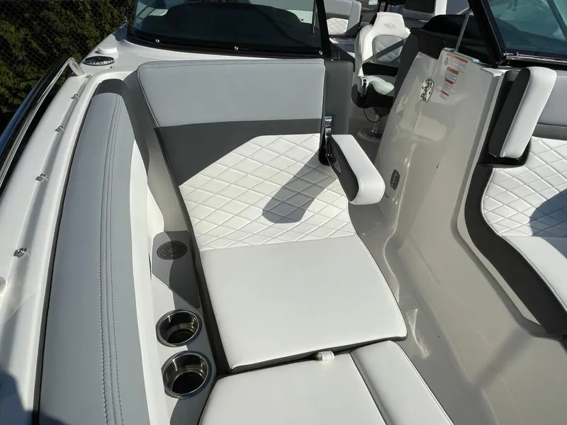 Slide: The Image of 2025 Chaparral 267 SSX boat interior with white cushioned seating and cup holders. - 16