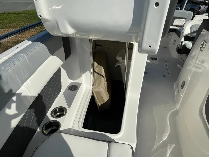 Slide: The Image of 2025 Chaparral 267 SSX boat interior with storage compartment and cup holders. - 17