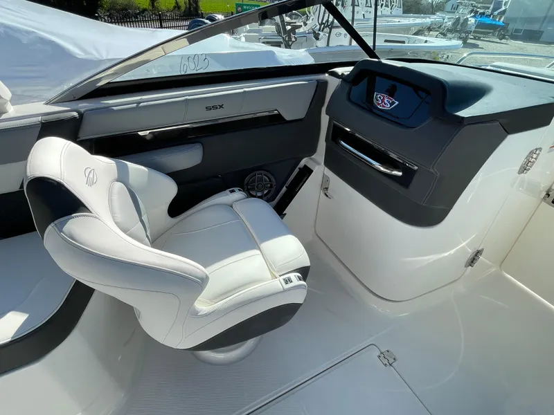 Slide: The Image of 2025 Chaparral 267 SSX boat interior with white captain's chair and sleek dashboard design. - 25