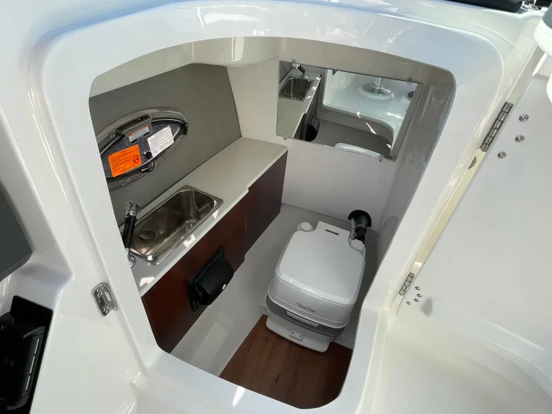 Slide: The Image of 2025 Chaparral 267 SSX boat interior with sink and portable toilet. - 28