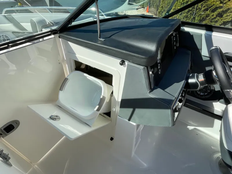 Slide: The Image of 2025 Chaparral 267 SSX boat interior with helm and storage compartment. - 31