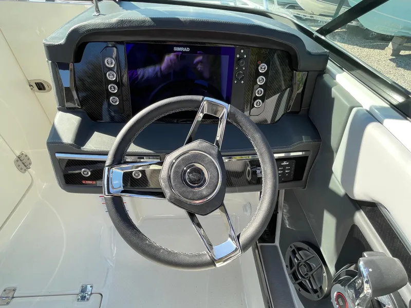 Slide: The Image of 2025 Chaparral 267 SSX boat dashboard with steering wheel and control panel. - 33