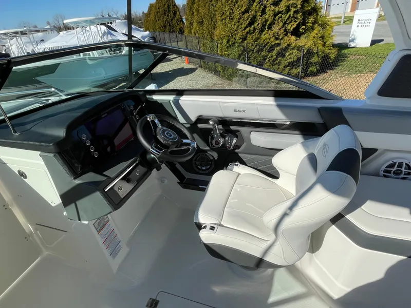 Slide: The Image of 2025 Chaparral 267 SSX boat cockpit with modern steering and white seating. - 37