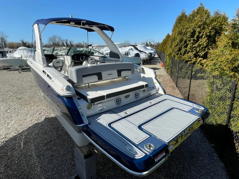 Slide: The Image of 2025 Chaparral 267 SSX boat with spacious deck and modern design, parked outdoors. - 5