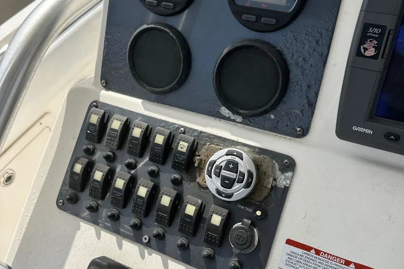 Slide: The Image of Control panel of a 2006 Robalo R240 Center Console boat with switches and gauges. - 11