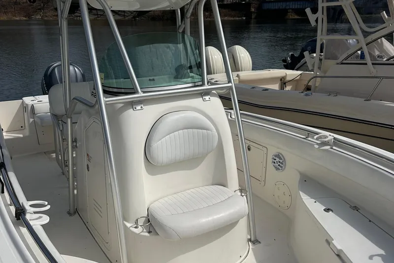 Slide: The Image of 2006 Robalo R240 Center Console boat with seating, docked on calm water. - 4