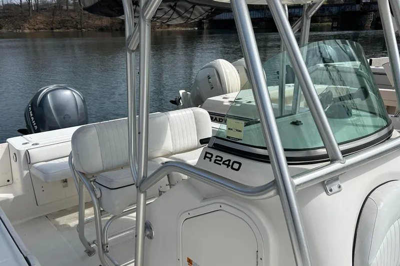 Slide: The Image of 2006 Robalo R240 Center Console boat on calm water, featuring dual outboard engines. - 5