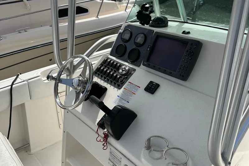 Slide: The Image of 2006 Robalo R240 Center Console boat dashboard with steering wheel and navigation controls. - 8