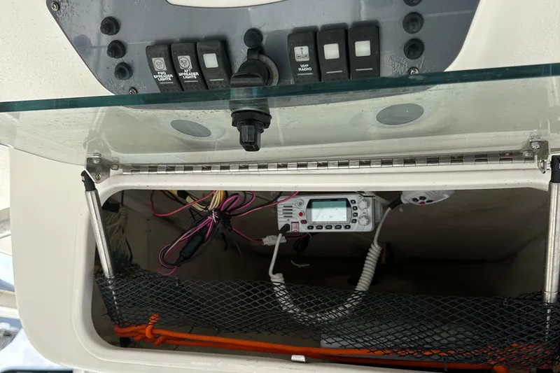 Slide: The Image of 2006 Robalo R240 Center Console dashboard with switches and storage compartment. - 9