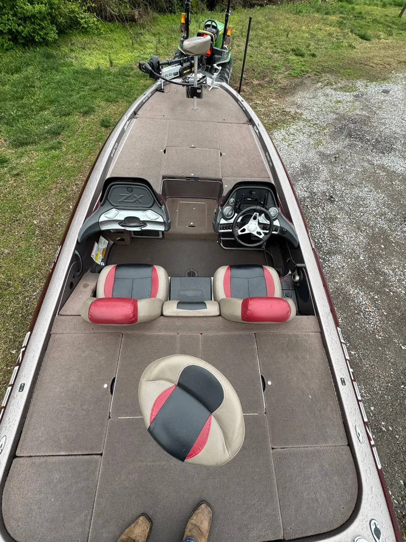 Slide: The Image of 2012 Skeeter ZX 21 boat interior with red and black seats, steering console, and fishing gear. - 7