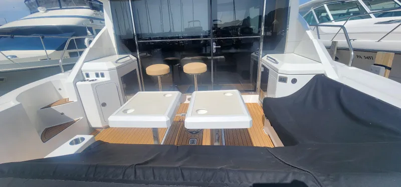 Slide: The Image of 2014 Cruisers Cantius yacht deck with seating, tables, and bar stools. - 10