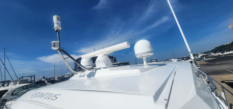 Slide: The Image of 2014 Cruisers Cantius yacht with radar equipment under a clear blue sky at a marina. - 13