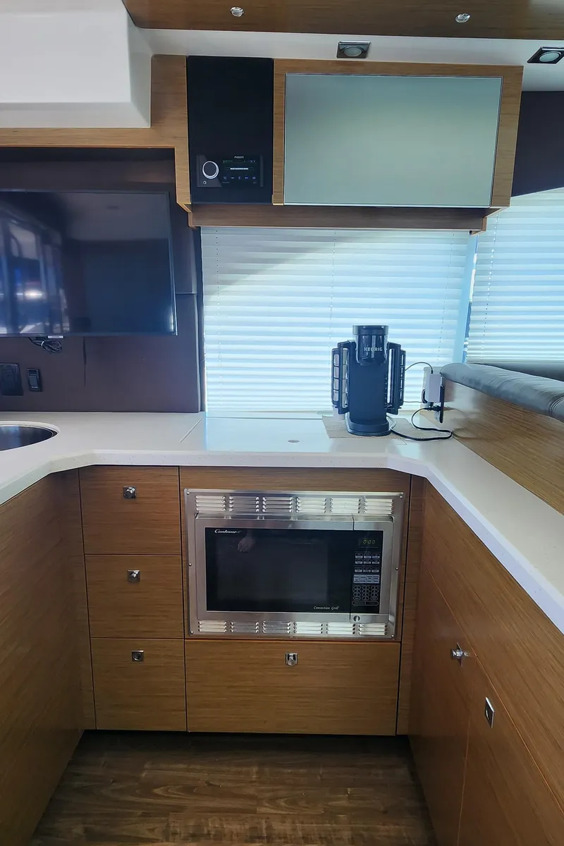 Slide: The Image of 2014 Cruisers Cantius yacht kitchen with microwave, coffee maker, and modern cabinetry. - 20