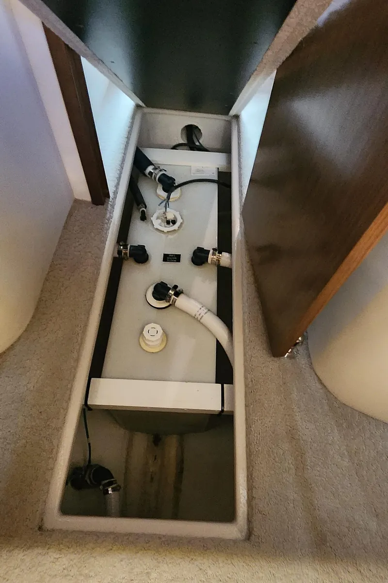 Slide: The Image of 2014 Cruisers Cantius boat interior showing a storage compartment with plumbing components. - 37