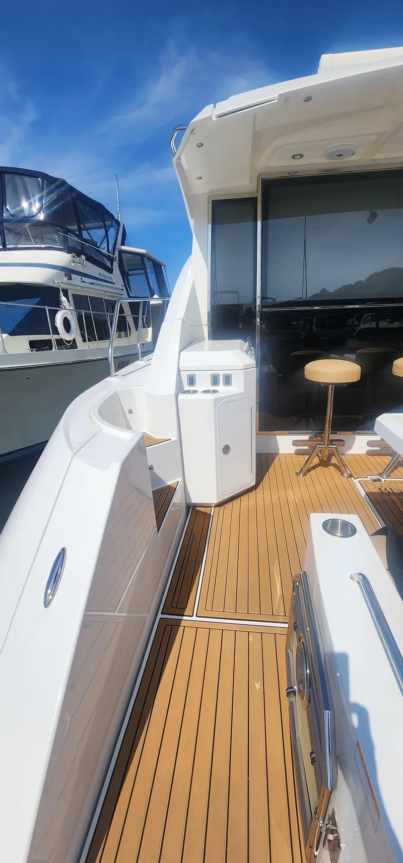 Slide: The Image of 2014 Cruisers Cantius yacht with sleek deck and modern seating under clear blue sky. - 11
