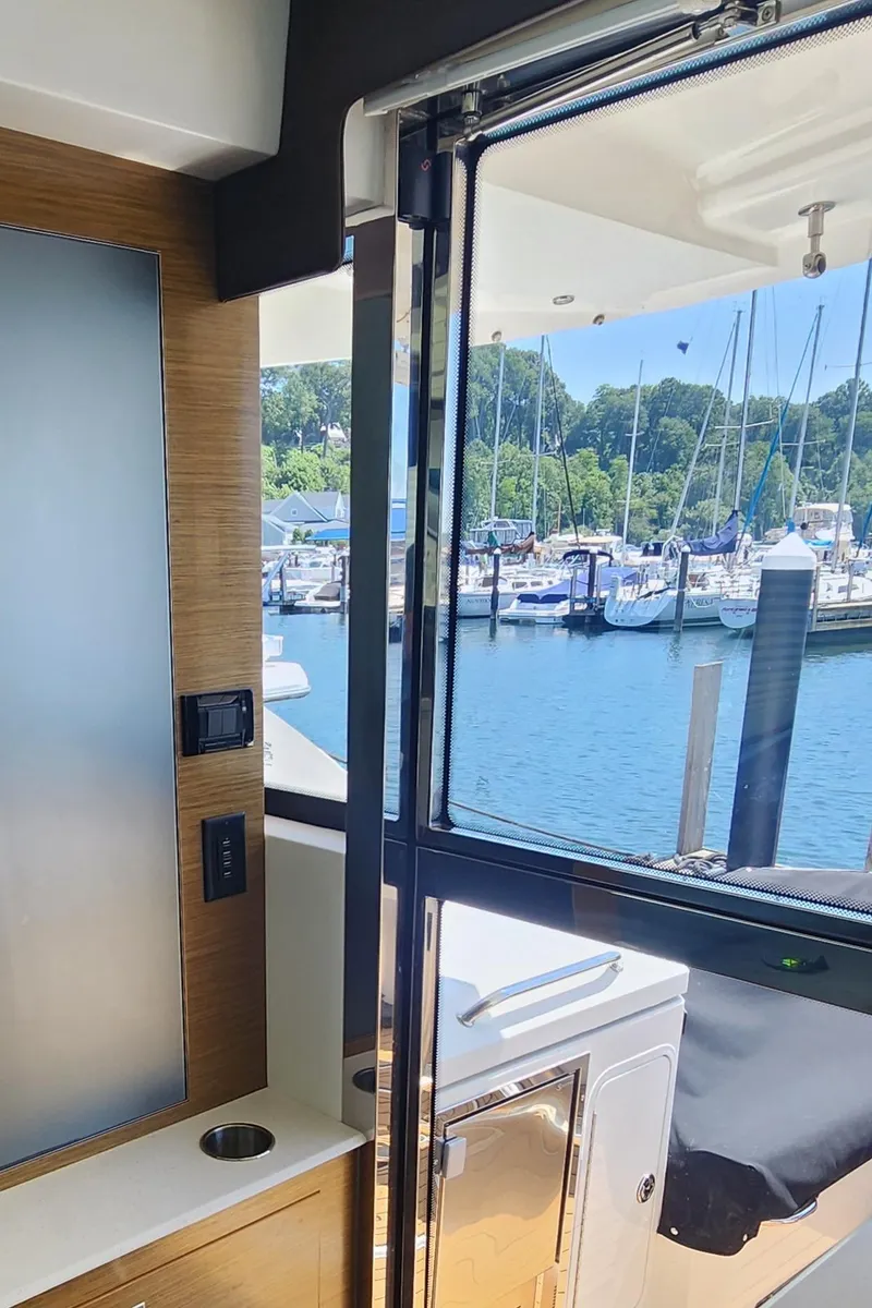 Slide: The Image of Interior view of 2014 Cruisers Cantius yacht with marina in the background. - 19