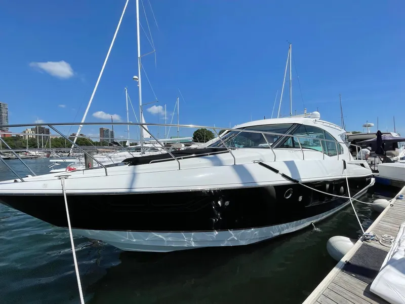 Slide: The Image of 2014 Cruisers Cantius yacht docked at marina under clear blue sky. - 2