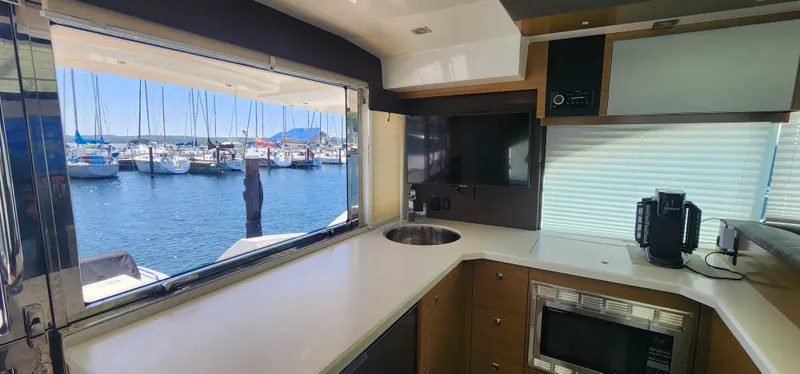 Slide: The Image of Interior of 2014 Cruisers Cantius yacht with modern kitchen and marina view. - 21