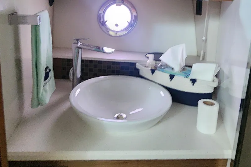 Slide: The Image of 2014 Cruisers Cantius bathroom with round sink, towel, and porthole window. - 32