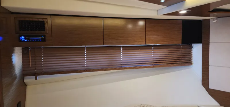 Slide: The Image of 2014 Cruisers Cantius interior with wooden cabinets and blinds. - 43