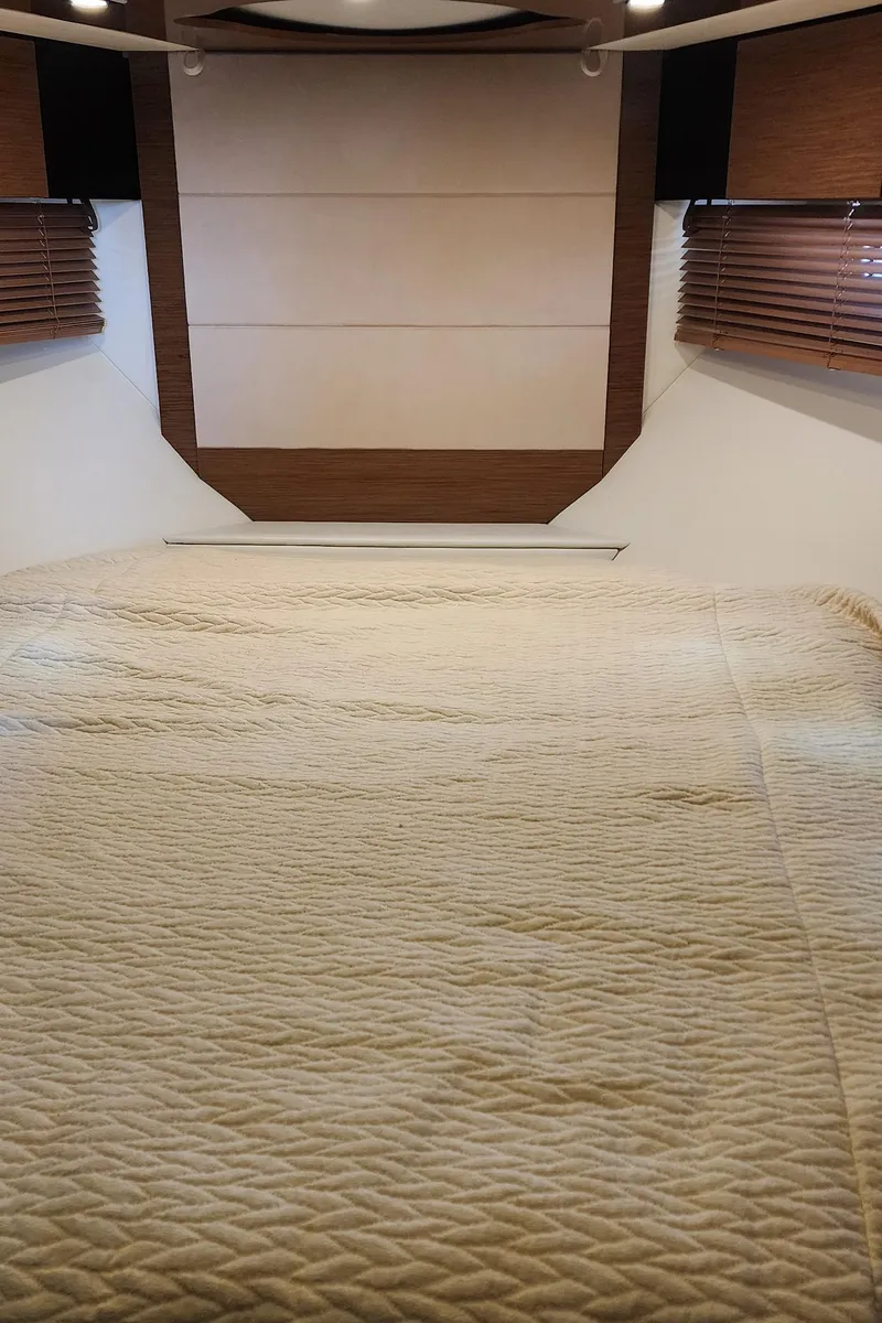 Slide: The Image of 2014 Cruisers Cantius cabin interior with beige bedding and wooden accents. - 46