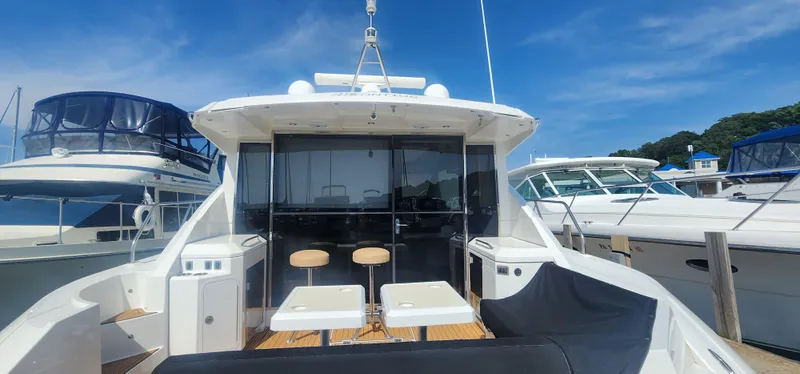 Slide: The Image of 2014 Cruisers Cantius yacht docked, featuring outdoor seating and sleek design under a clear blue sky. - 7