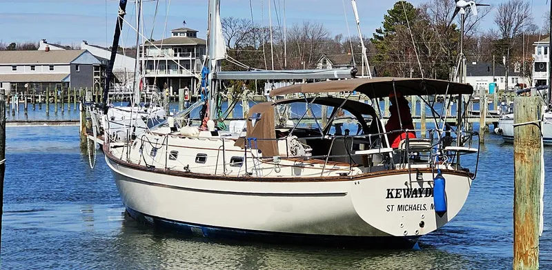 The Image of Island Packet 40 sailboat, 1997 model, docked in a marina with surrounding buildings. - 0