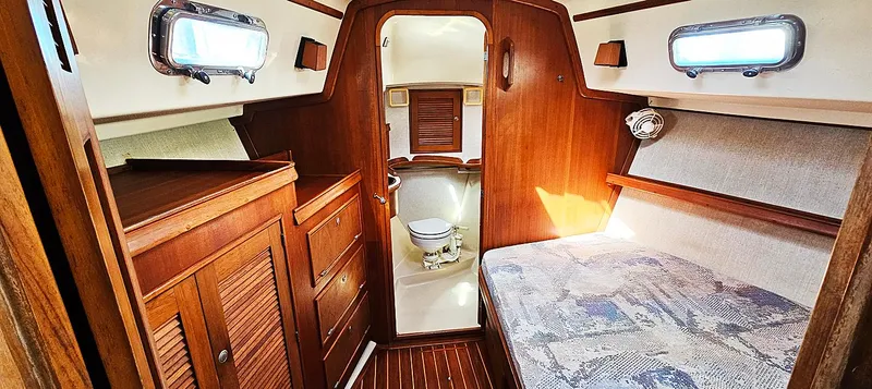 Slide: The Image of 1997 Island Packet 40 yacht interior with wooden cabinetry, bed, and compact bathroom. - 10