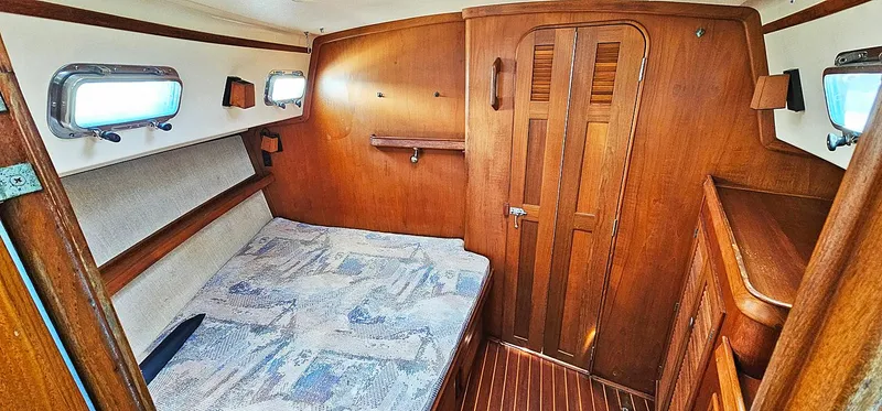 Slide: The Image of Cozy cabin interior of 1997 Island Packet 40 sailboat with wooden finish and bed. - 11