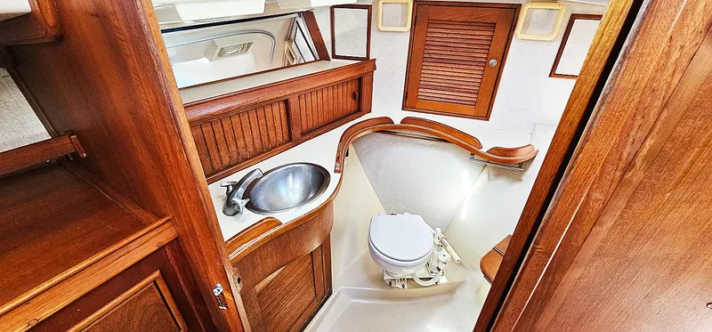 Slide: The Image of 1997 Island Packet 40 yacht bathroom with wooden cabinetry and stainless steel sink. - 13
