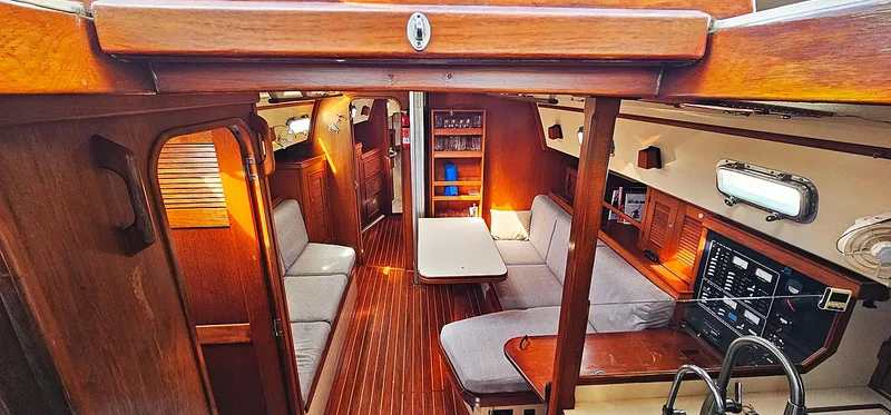 Slide: The Image of Interior of 1997 Island Packet 40 sailboat with cozy seating and wooden finishes. - 2
