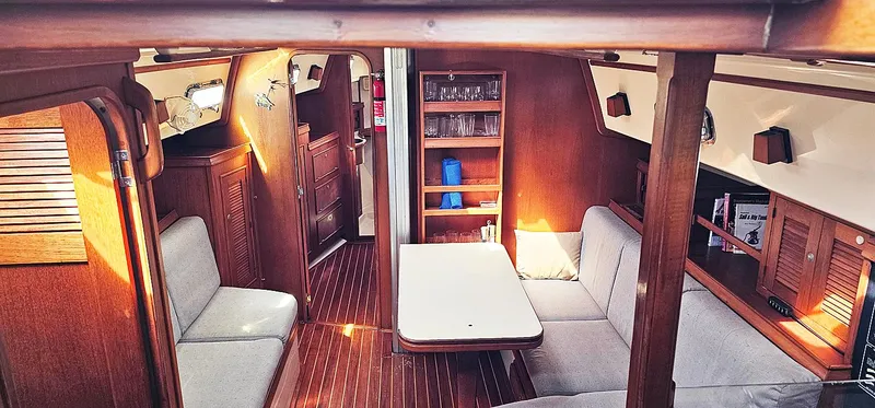 Slide: The Image of Interior of 1997 Island Packet 40 sailboat with cozy seating and wooden finishes. - 3