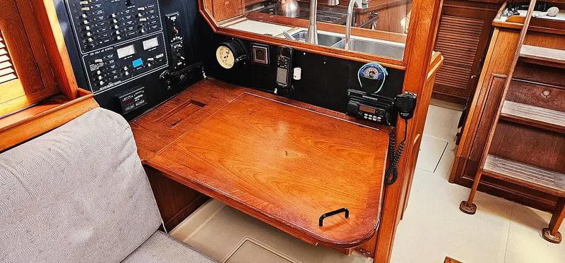 Slide: The Image of Navigation station on a 1997 Island Packet 40 sailboat with wooden desk and control panel. - 6