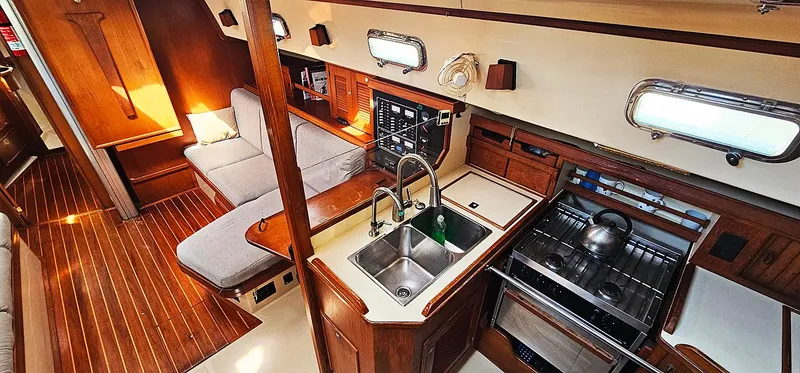Slide: The Image of Interior of 1997 Island Packet 40 sailboat with wood finish and modern kitchen amenities. - 7
