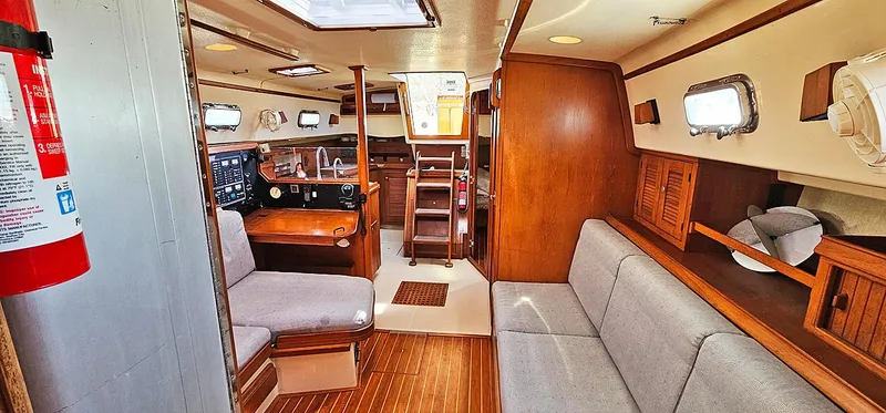 Slide: The Image of Interior of 1997 Island Packet 40 sailboat with wood finish and seating area. - 8
