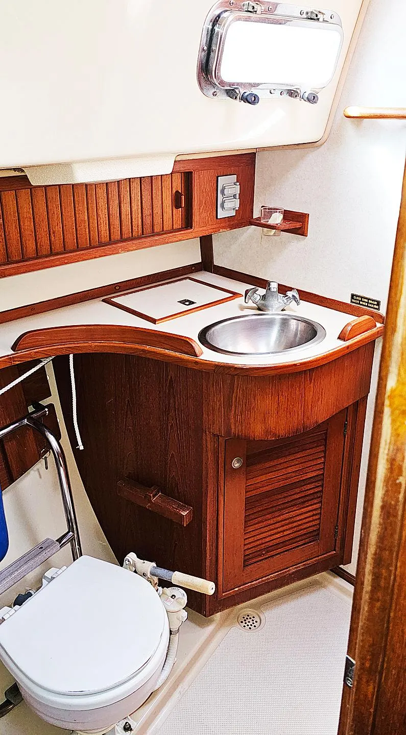 Slide: The Image of 1997 Island Packet 40 yacht bathroom with wooden cabinetry and stainless steel sink. - 9