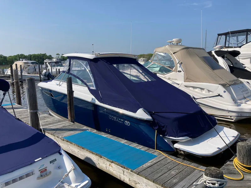 Slide: The Image of 2018 Cobalt R35 boat docked with blue cover in marina. - 19