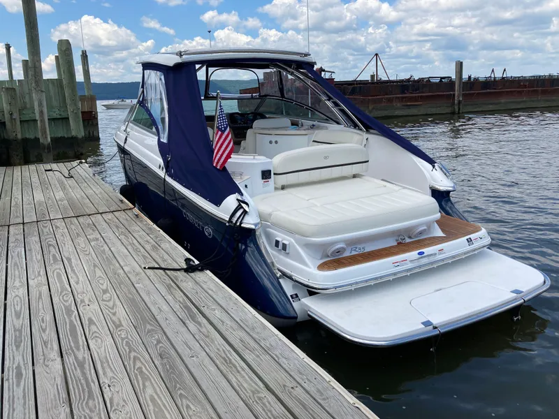 Slide: The Image of 2018 Cobalt R35 boat docked, featuring a sleek design and American flag. - 2