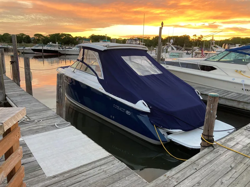 Slide: The Image of 2018 Cobalt R35 boat docked at sunset with protective cover. - 20