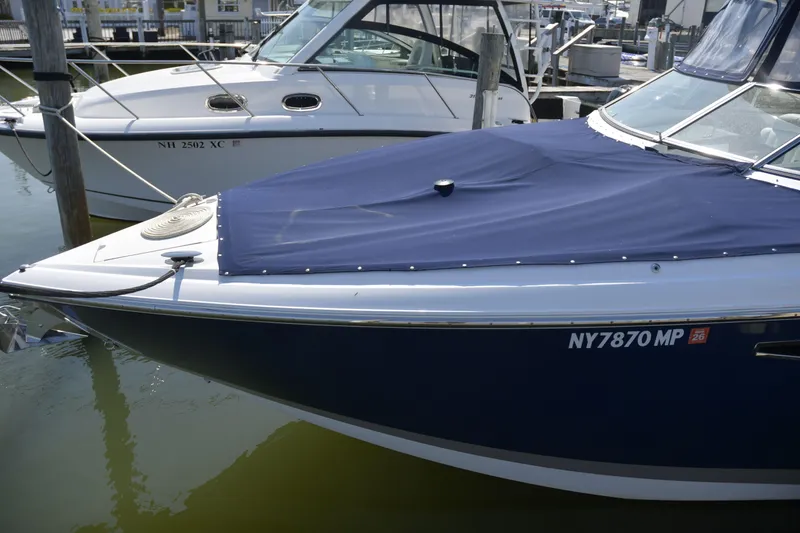 Slide: The Image of 2018 Cobalt R35 boat docked with blue cover, adjacent to another vessel. - 21