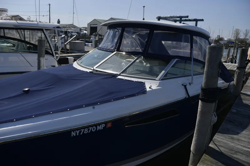 Slide: The Image of 2018 Cobalt R35 boat docked at a marina with a blue cover. - 22