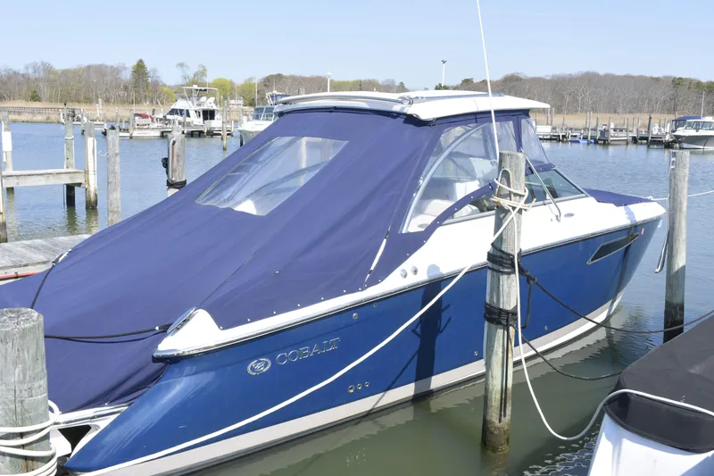 Slide: The Image of 2018 Cobalt R35 boat docked with blue cover in a marina. - 24