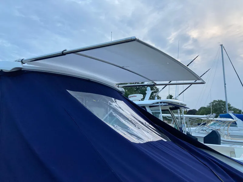 Slide: The Image of 2018 Cobalt R35 boat with blue canopy and extended sunshade at marina. - 4