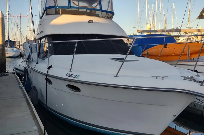 The Image of 1992 Carver 33 Aft Cabin yacht docked at marina with sailboats in background. - 1