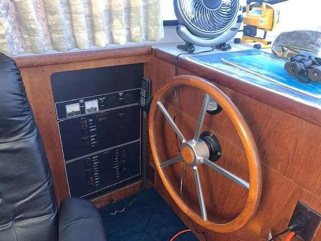 Slide: The Image of 1992 Carver 33 Aft Cabin helm with wooden steering wheel and control panel. - 10