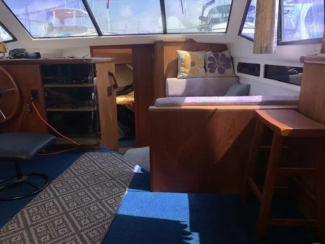 Slide: The Image of Interior of 1992 Carver 33 Aft Cabin with seating, helm, and blue carpet. - 22